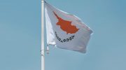Cyprus national flag on a flagpole against a clear blue sky